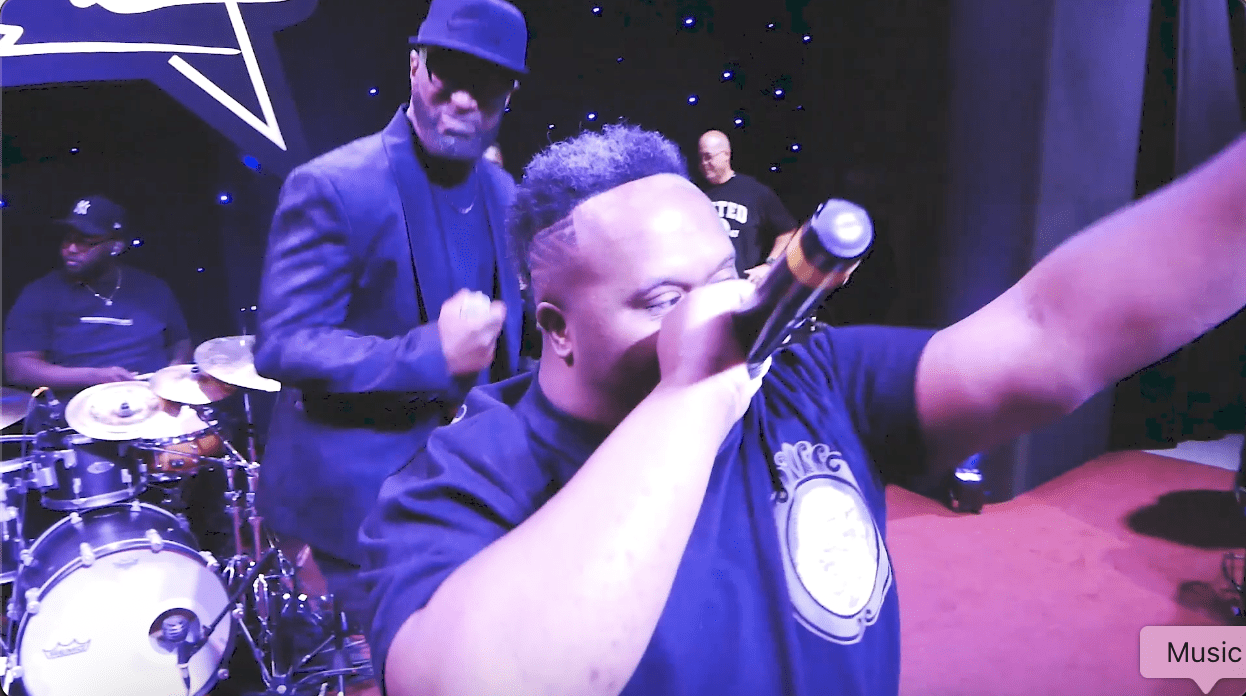Live rap performance with microphone on stage.